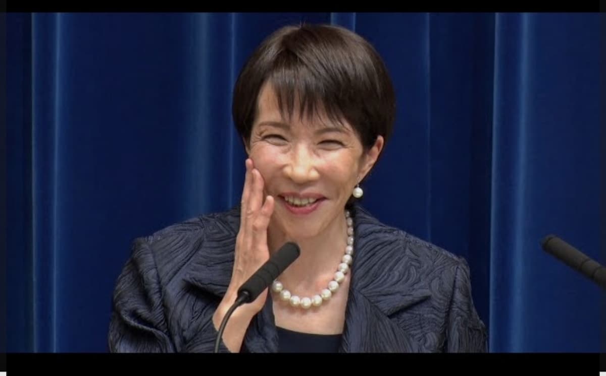 高市早苗さんが微笑みながら頬に手をあてる様子