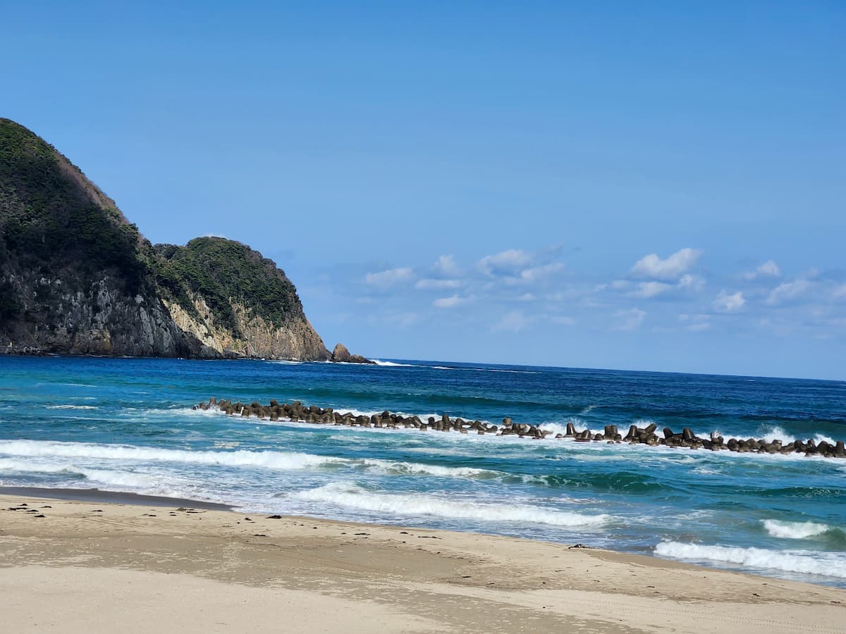 冬の竹野浜に波が打ち寄せている 誰もいない様子