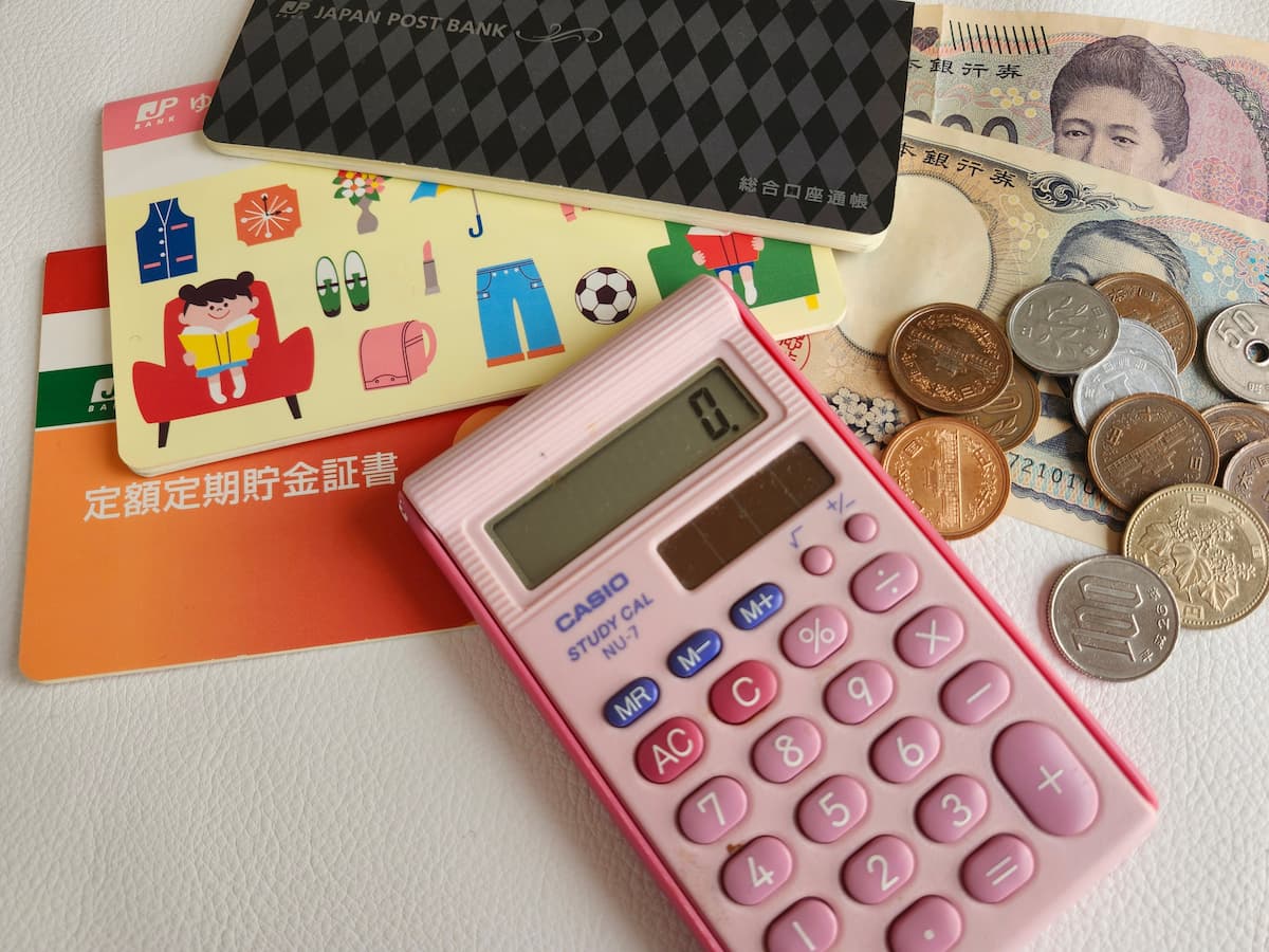 お札と小銭と電卓と銀行通帳