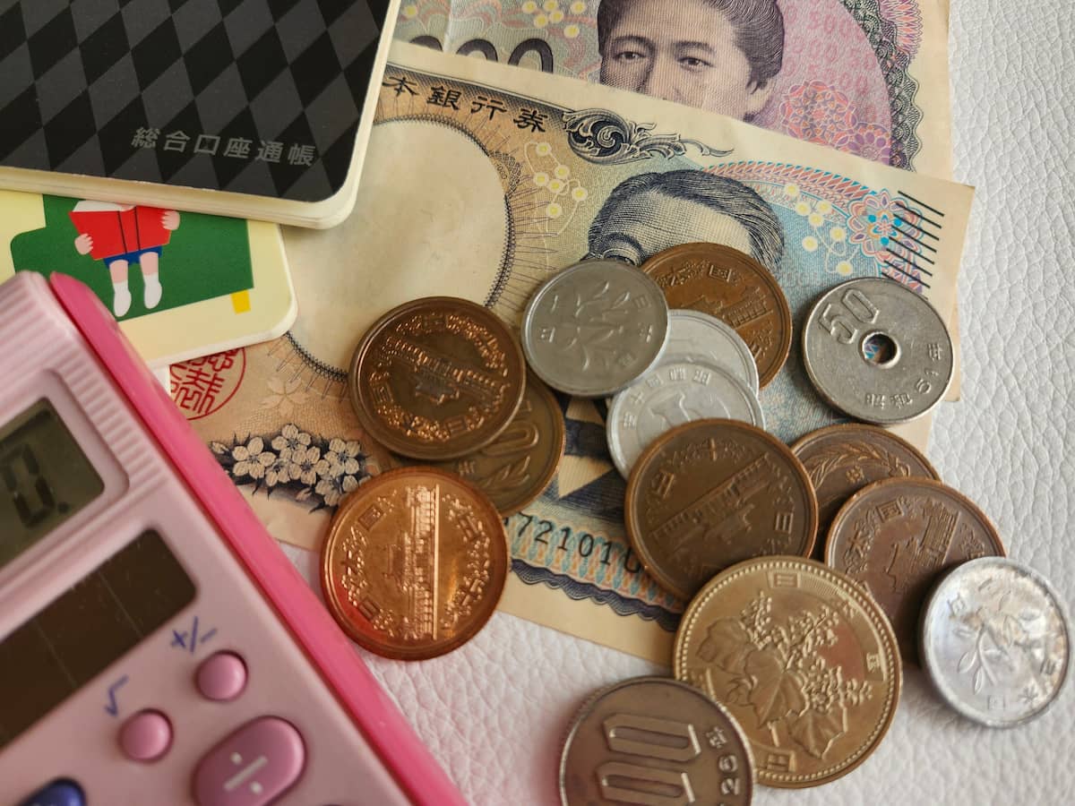 お金とピンクの電卓と通帳