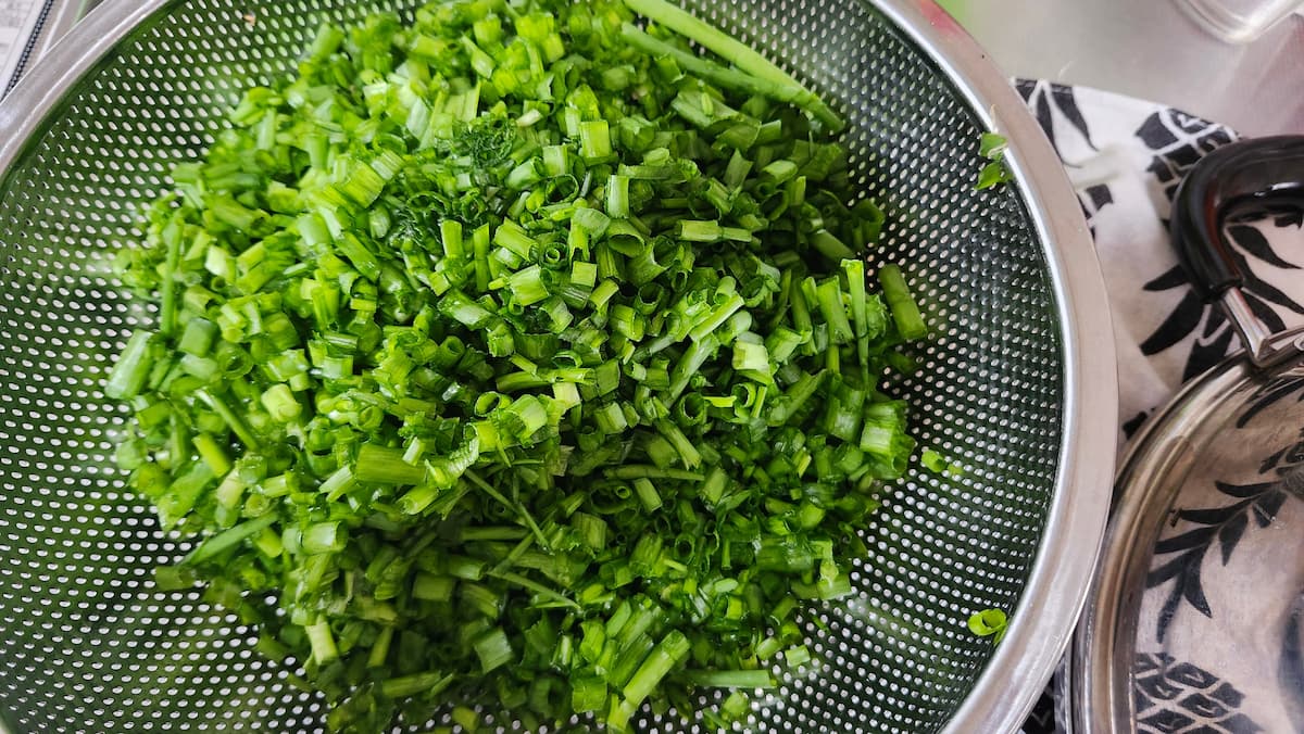 家庭菜園のワケギを小口切りしてザルに入れた様子