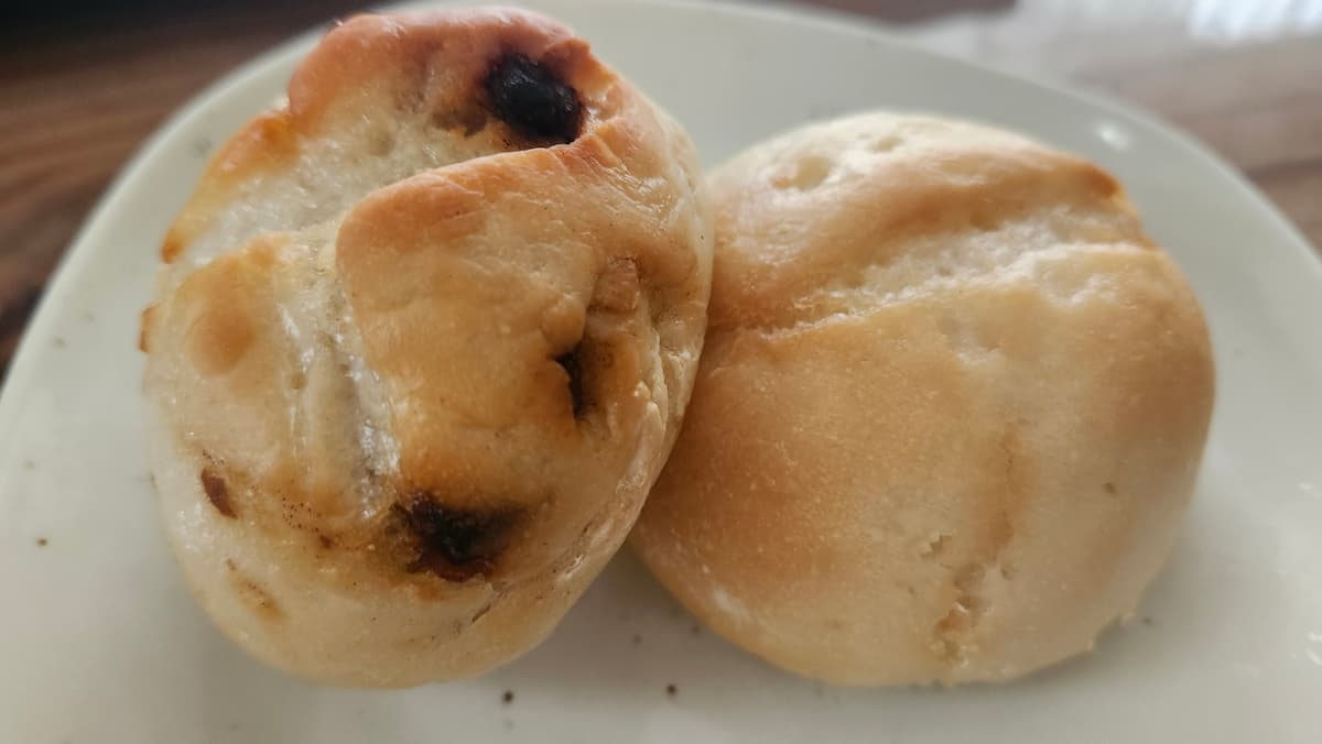 米粉パンのプレーンとレーズン入り2個が白い皿に乗った様子