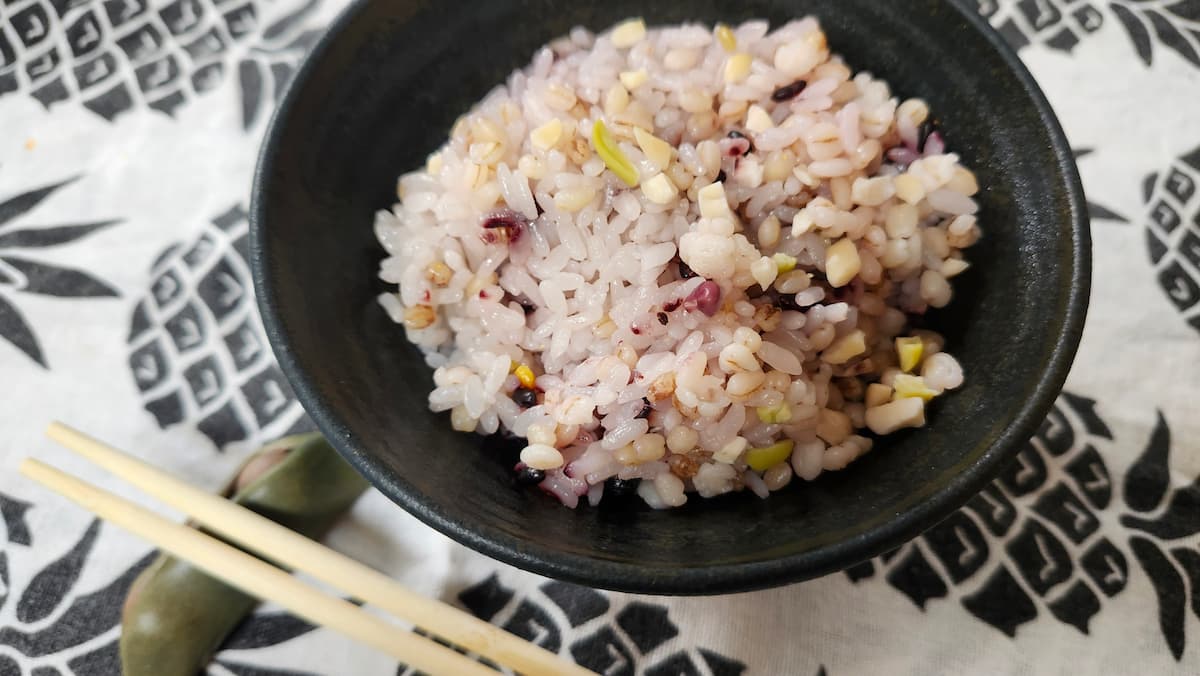 丹波焼きの黒いお茶碗に入った雑穀米と白米を混ぜて炊いたご飯
